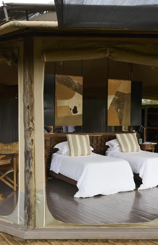 Twin beds with striped pillows in open-sided safari lodge bedroom, Leopard Hill, Maasai Mara, Kenya