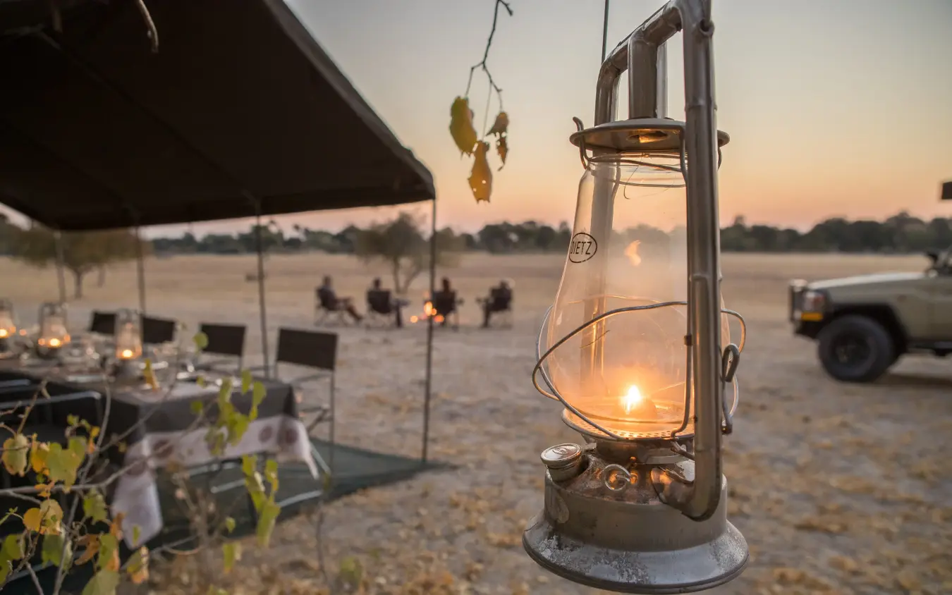 Lantern glowing at dusk in safari camp setting, Botswana