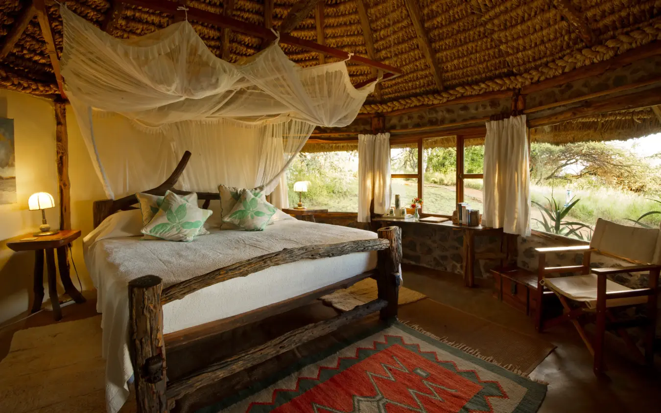 Canopied bed in thatched-roof safari bedroom with views, Lewa House, Laikipia Highlands, Kenya