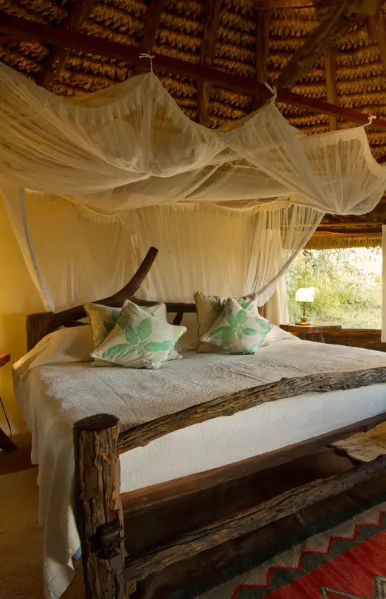 Canopied bed in thatched-roof safari bedroom with views, Lewa House, Laikipia Highlands, Kenya