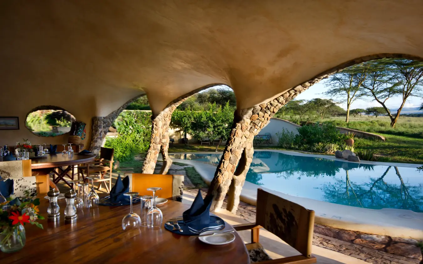 Open-air lounge with pool and savanna views through arches, Lewa House, Laikipia Highlands, Kenya