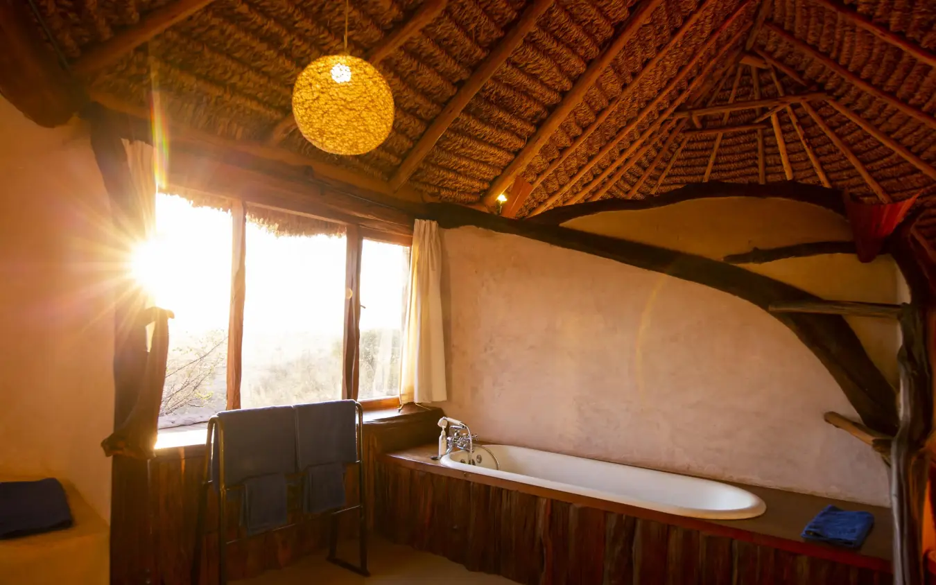 Luxury bathroom with soaking tub and thatched roof, Lewa Wilderness, Laikipia Highlands, Kenya