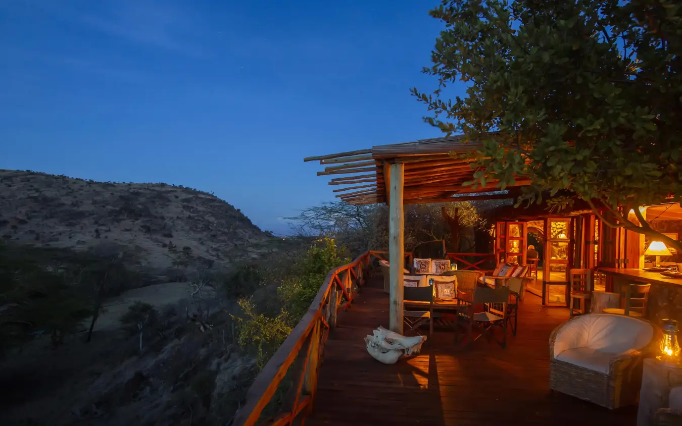 Wooden deck overlooking valley at dusk with warm lighting, Lewa Wilderness, Laikipia Highlands, Kenya