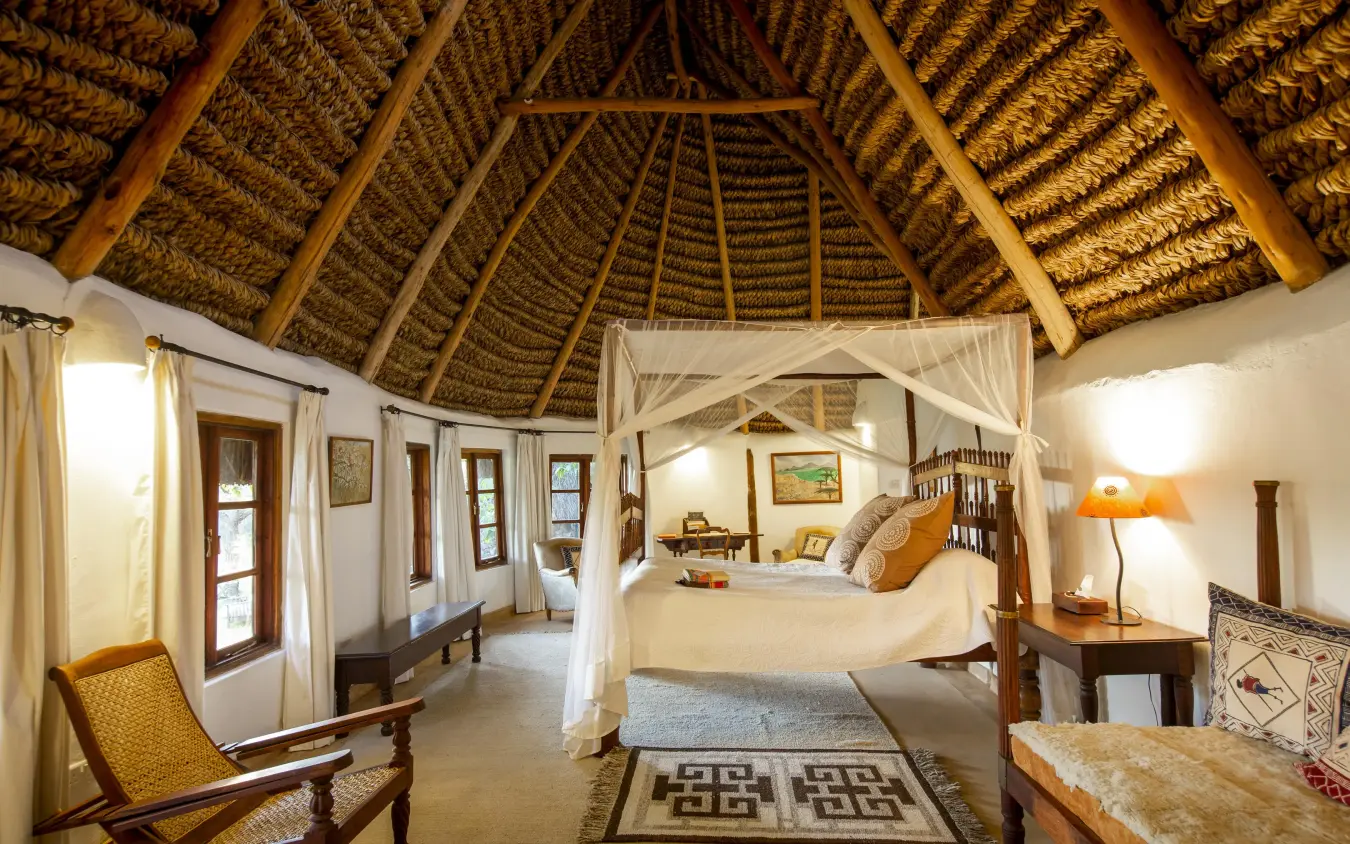 Spacious bedroom with thatched roof and four-poster bed, Lewa Wilderness, Laikipia Highlands, Kenya