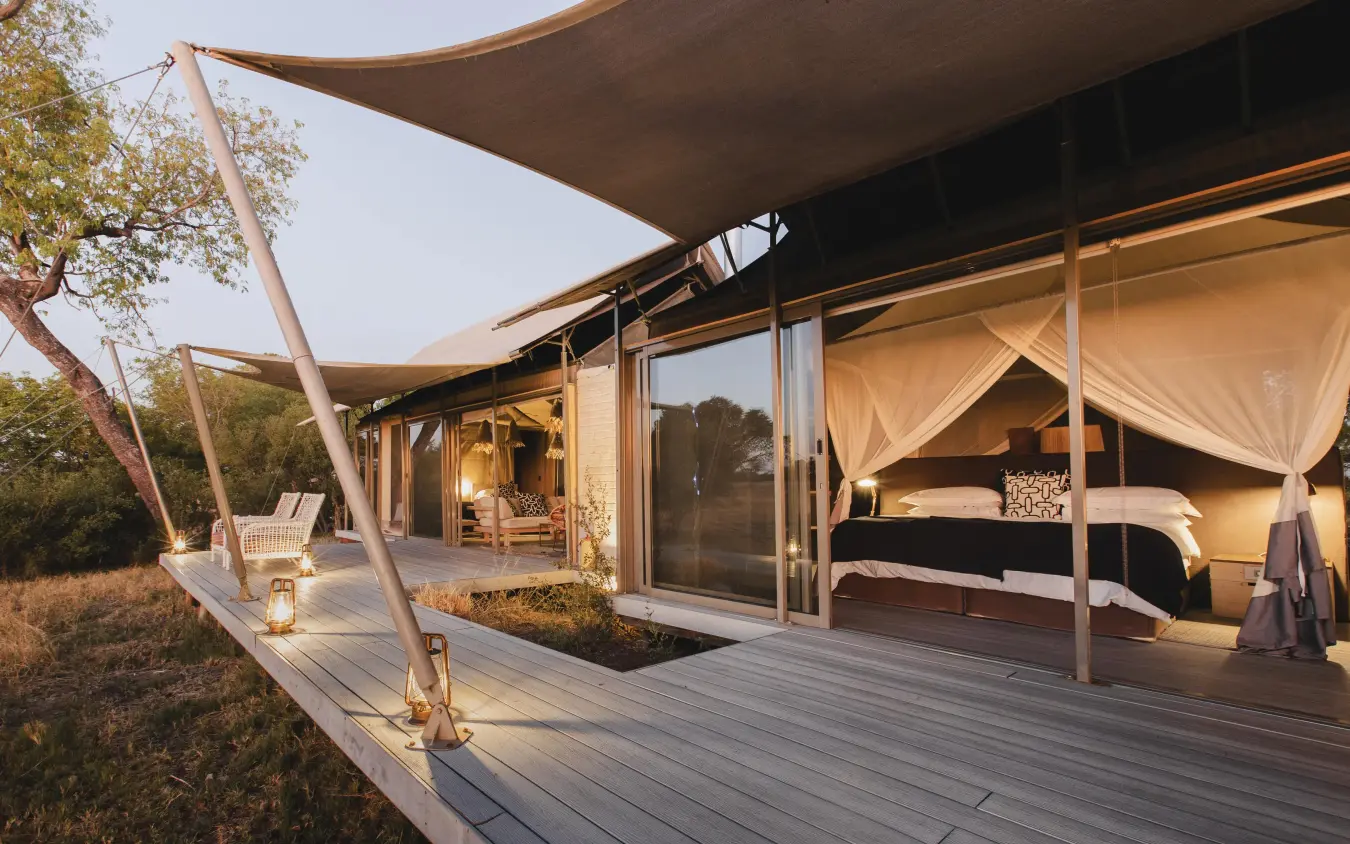 Safari suite with canopy bed and expansive deck at dusk, Linkwasha Camp, Hwange National Park, Zimbabwe