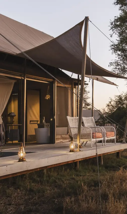 Safari lodge tent exterior at sunset with wooden deck, Linkwasha Camp, Hwange National Park, Zimbabwe