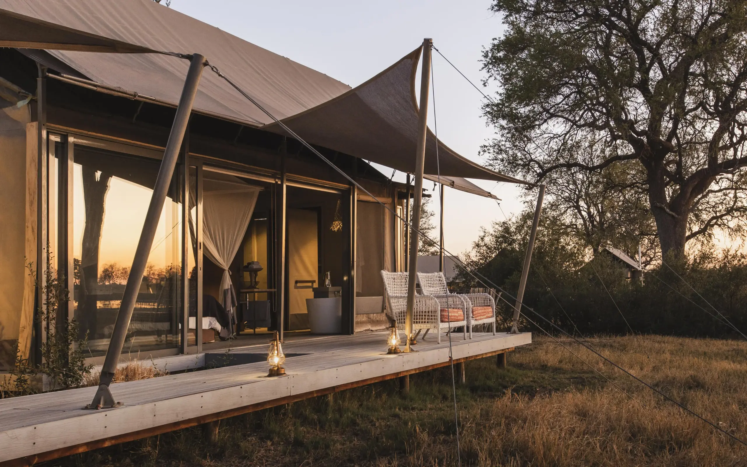 Safari lodge tent exterior at sunset with wooden deck, Linkwasha Camp, Hwange National Park, Zimbabwe