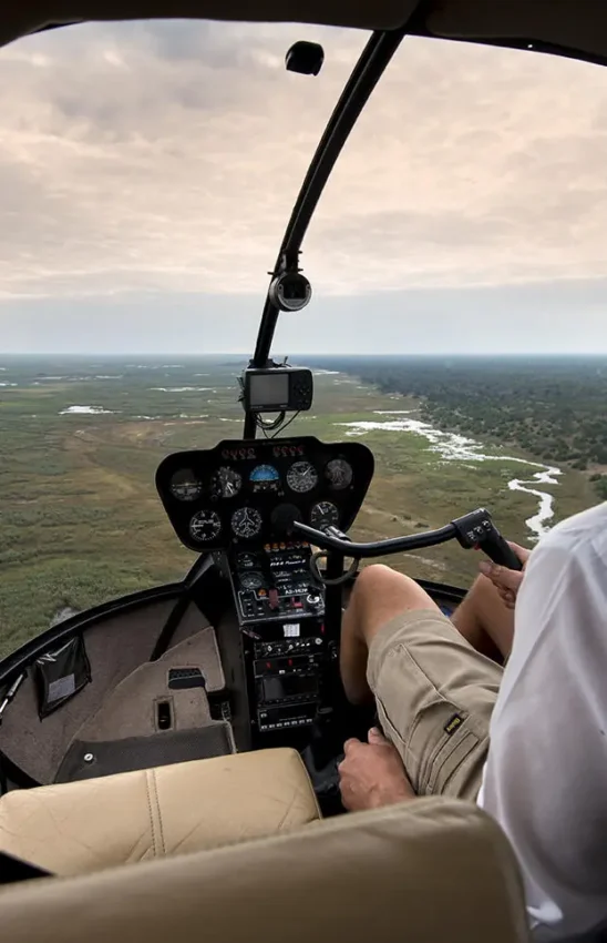 Helicopter pilot conducting aerial survey over African landscape, Linyanti Bush Camp, Linyanti Wildlife Reserve, Botswana