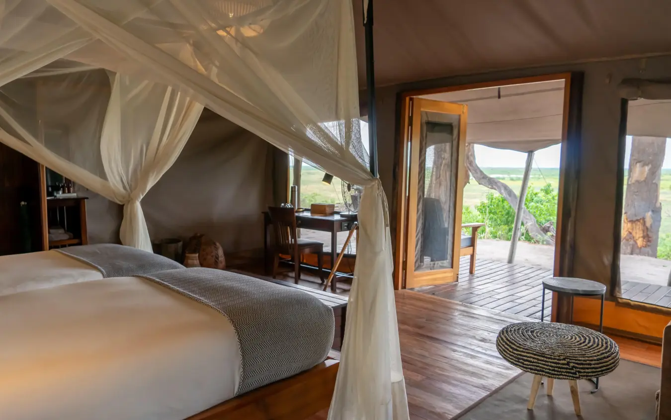Spacious bedroom with four-poster bed and deck views, Linyanti Bush Camp, Linyanti Wildlife Reserve, Botswana