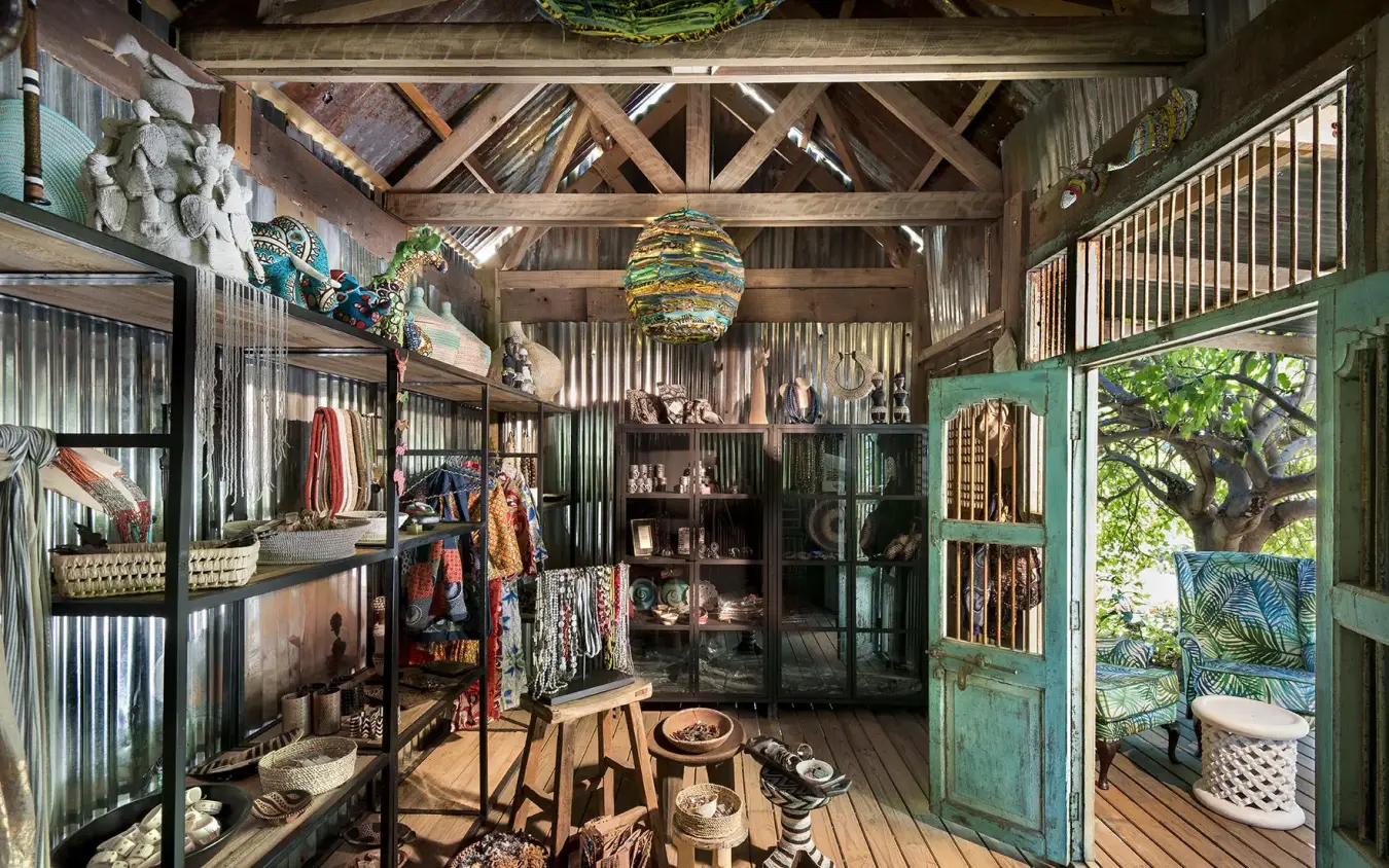 Rustic interior retail space with wooden beams and corrugated metal, Linyanti Bush Camp, Linyanti Wildlife Reserve, Botswana
