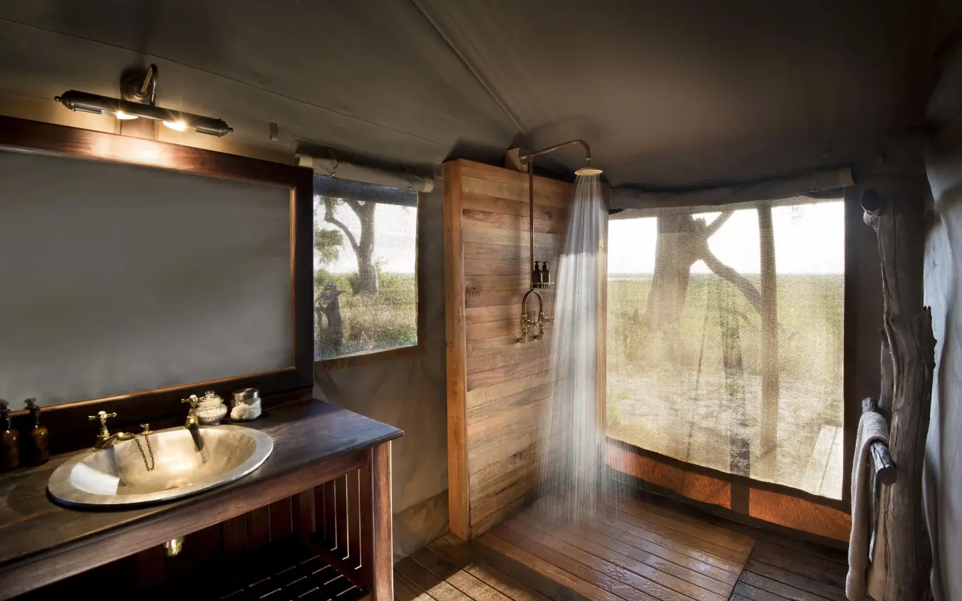 Luxury bathroom with wooden vanity and outdoor shower, Linyanti Ebony, Linyanti Wildlife Reserve, Botswana