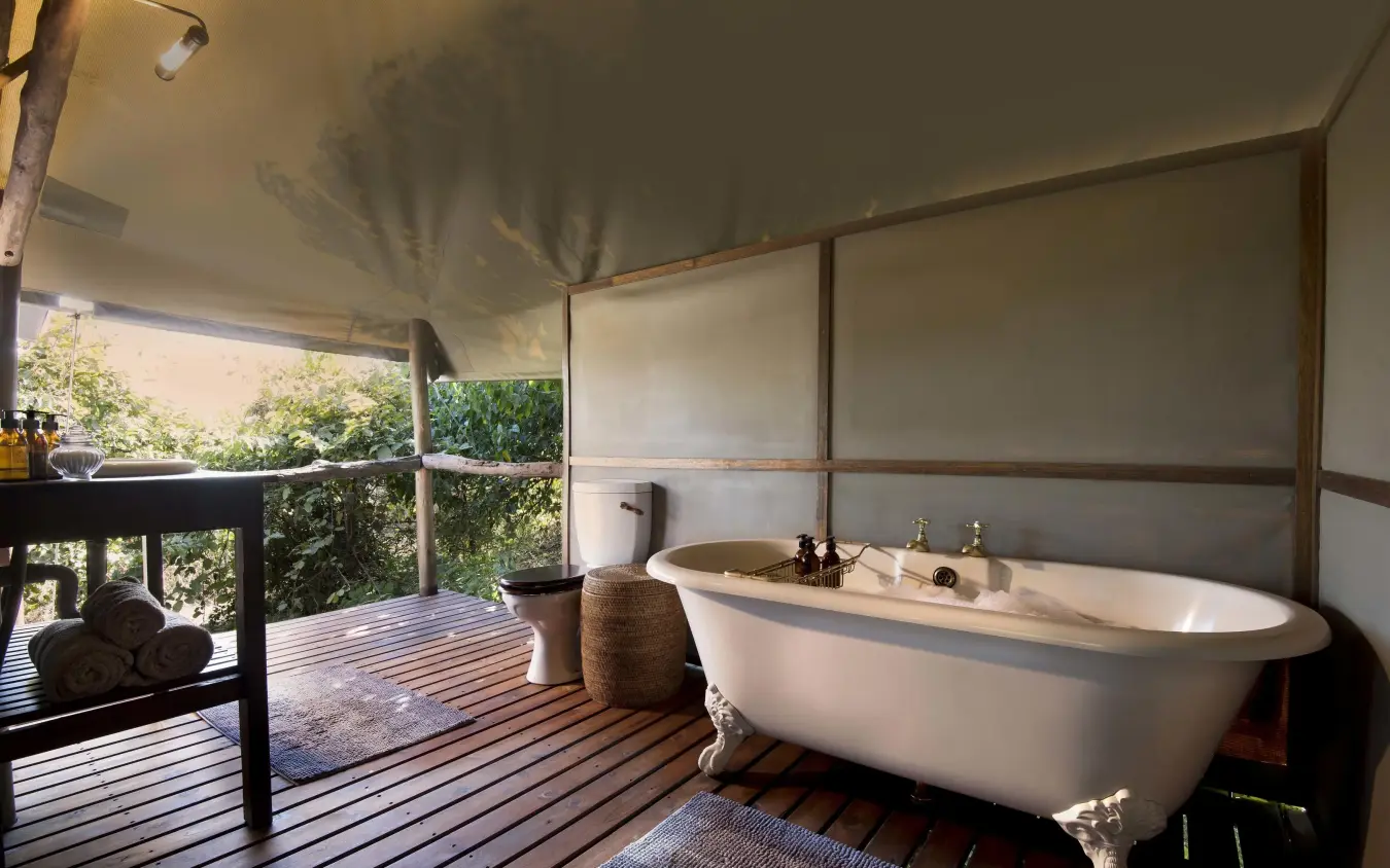 Outdoor bathroom with freestanding tub and wooden deck, Linyanti Ebony, Linyanti Wildlife Reserve, Botswana