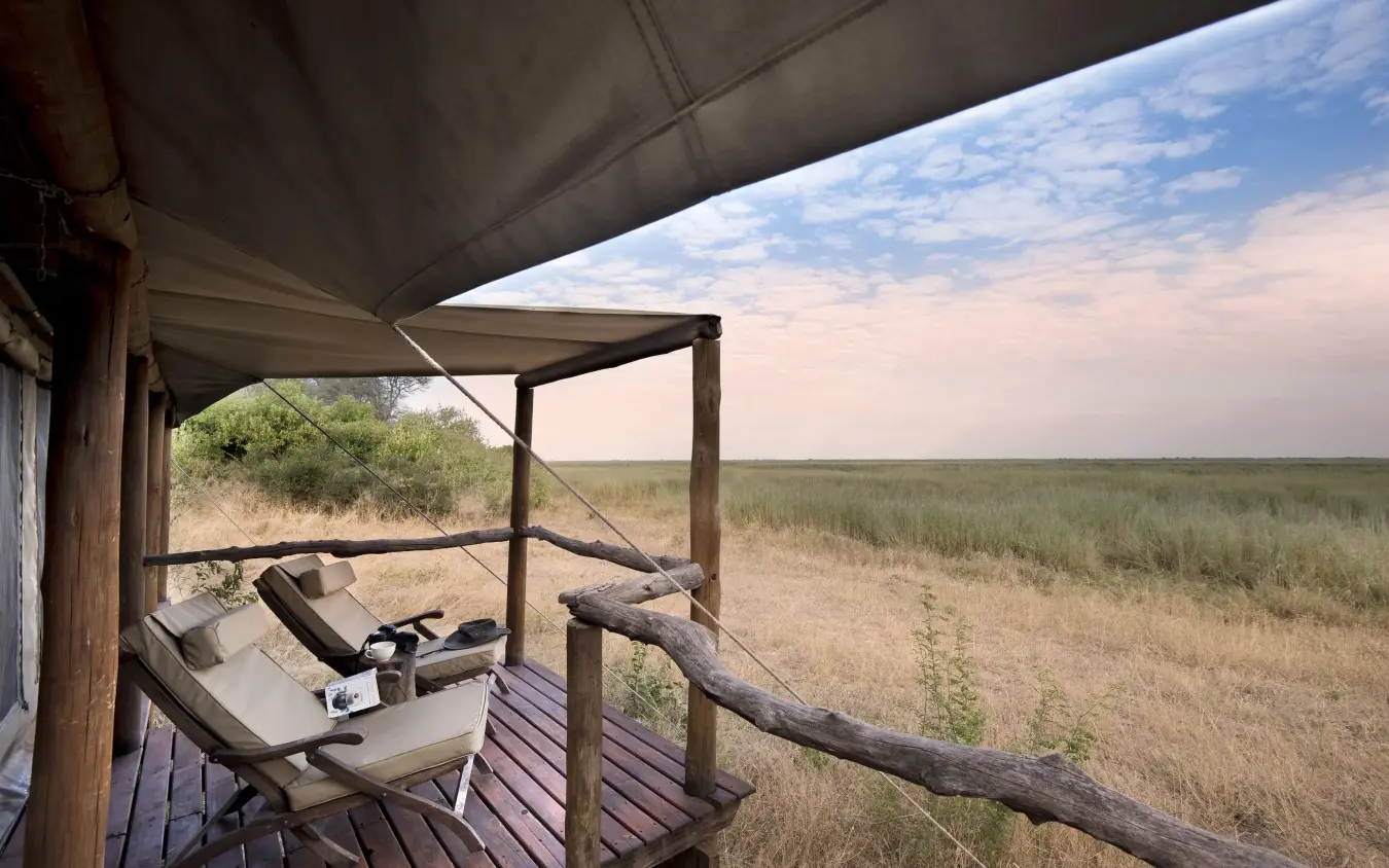 Wooden deck with lounge chairs overlooking savanna landscape, Linyanti Ebony, Linyanti Wildlife Reserve, Botswana