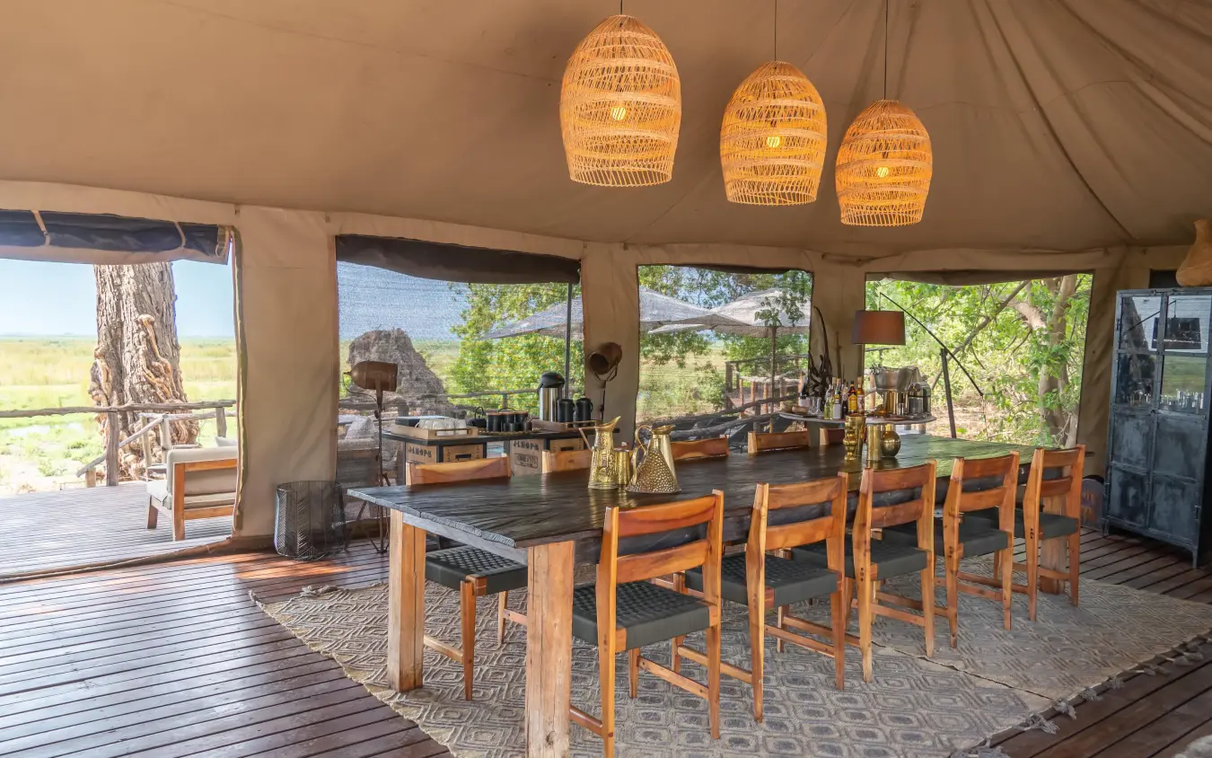 Open-air dining tent with wooden table and chairs, Linyanti Ebony, Linyanti Wildlife Reserve, Botswana