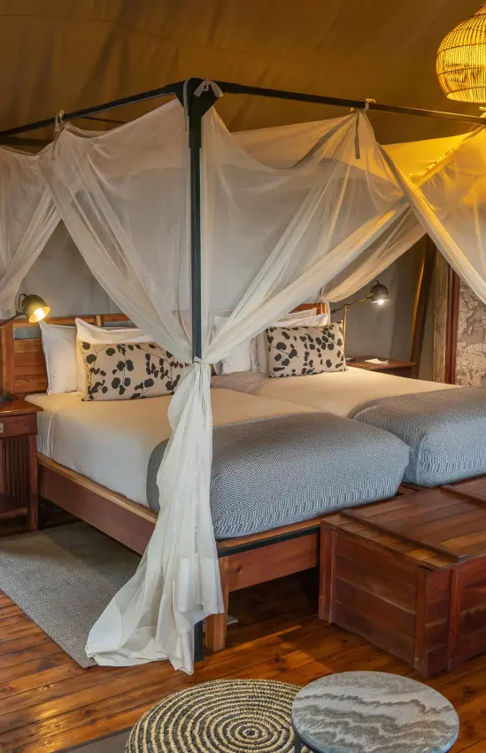 Luxury safari tent bedroom with four-poster bed and draped linens, Linyanti Ebony, Linyanti Wildlife Reserve, Botswana