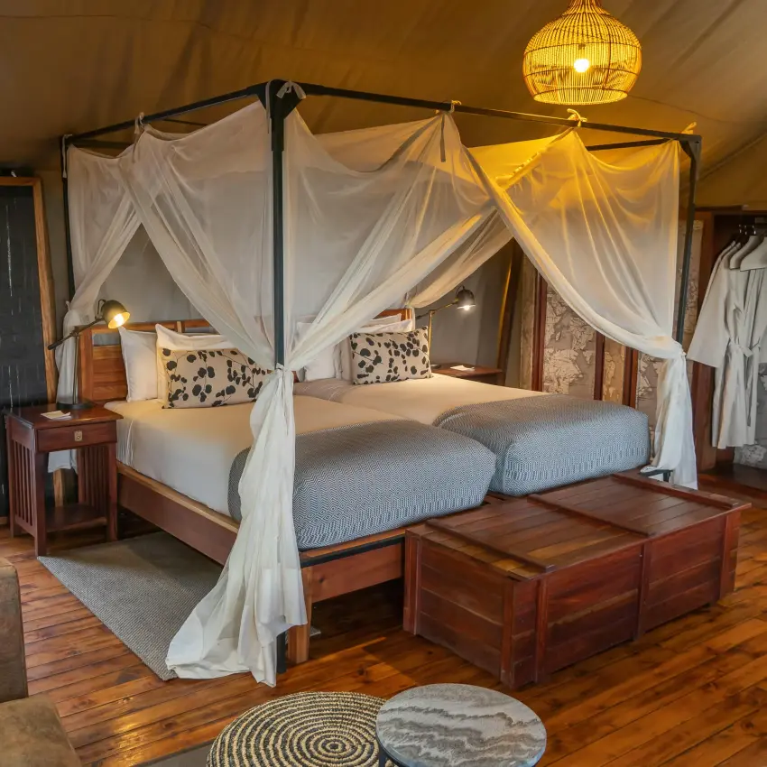 Luxury safari tent bedroom with four-poster bed and draped linens, Linyanti Ebony, Linyanti Wildlife Reserve, Botswana