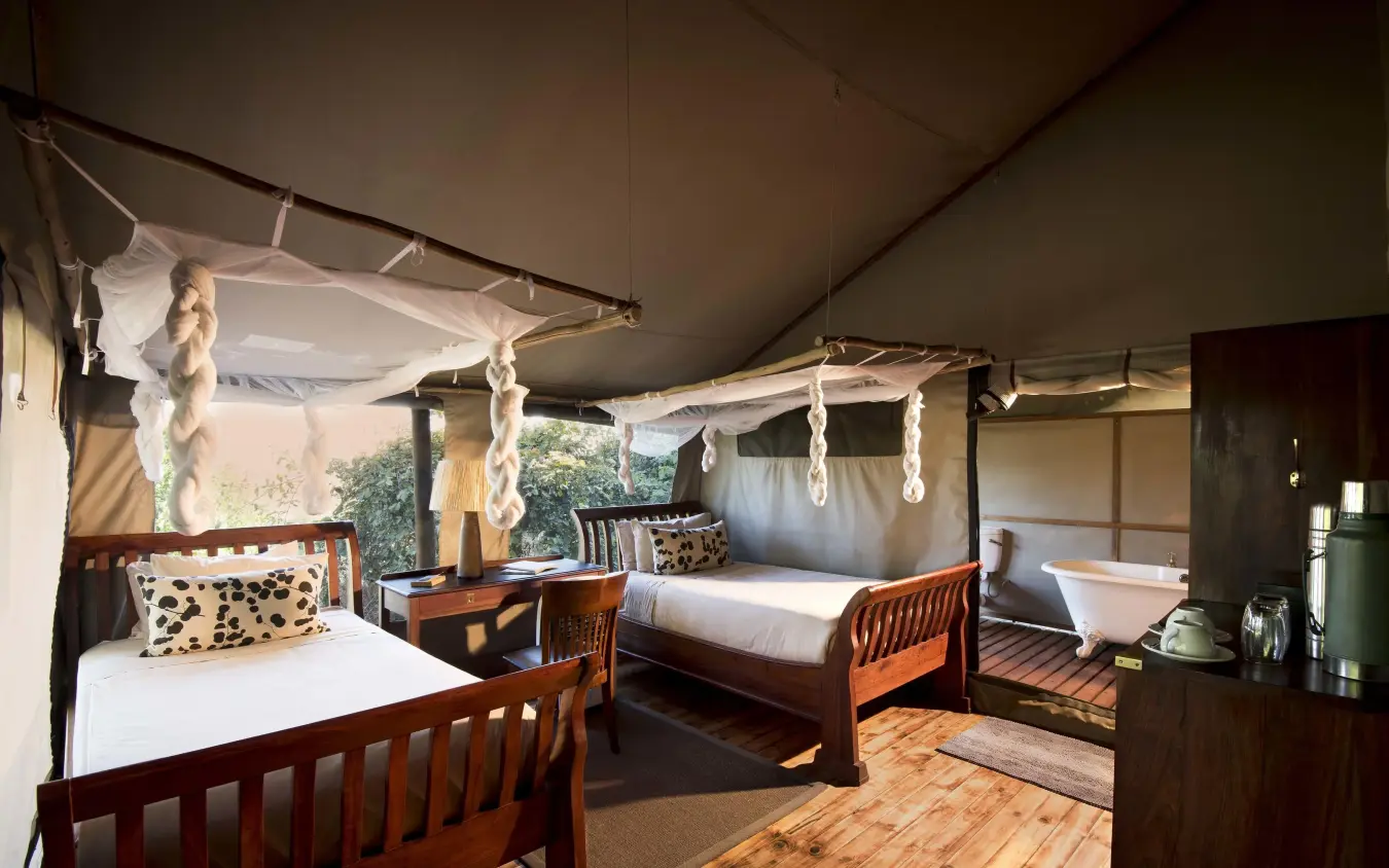 Luxury safari bedroom with wooden beds and canvas canopy, Linyanti Ebony, Linyanti Wildlife Reserve, Botswana