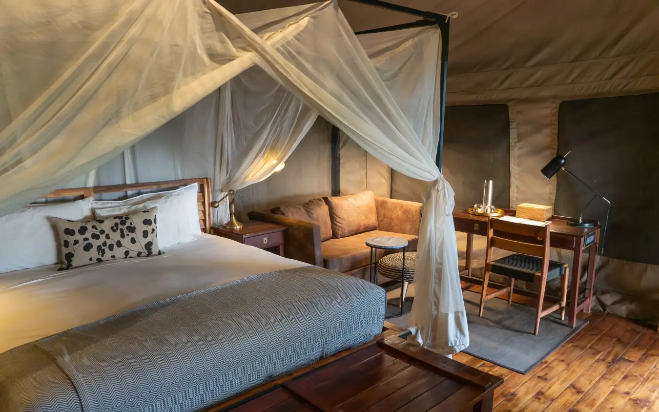 Luxury bedroom with four-poster canopy bed and seating area, Linyanti Ebony, Linyanti Wildlife Reserve, Botswana