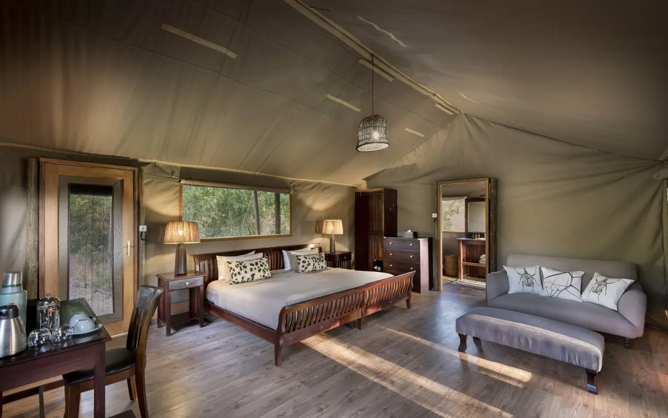 Spacious bedroom with wooden bed and canvas tent walls, Linyanti Ebony, Linyanti Wildlife Reserve, Botswana
