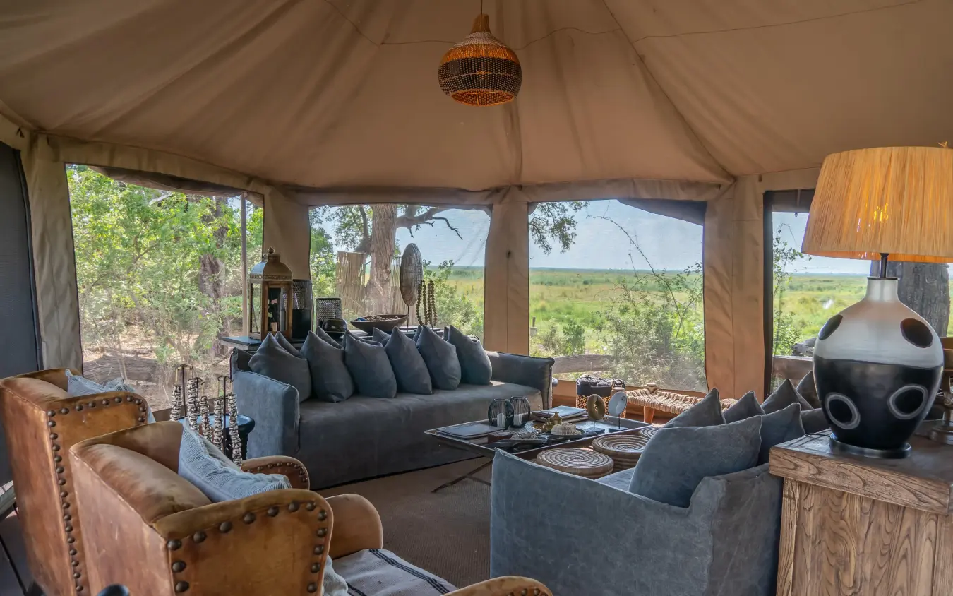 Safari tent lounge with leather chairs and savanna views, Linyanti Ebony, Linyanti Wildlife Reserve, Botswana