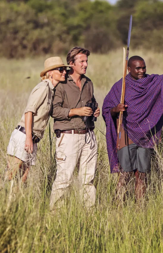 Guides and guests walking through grassland during safari, Little Chem Chem, Lake Manyara, Tanzania