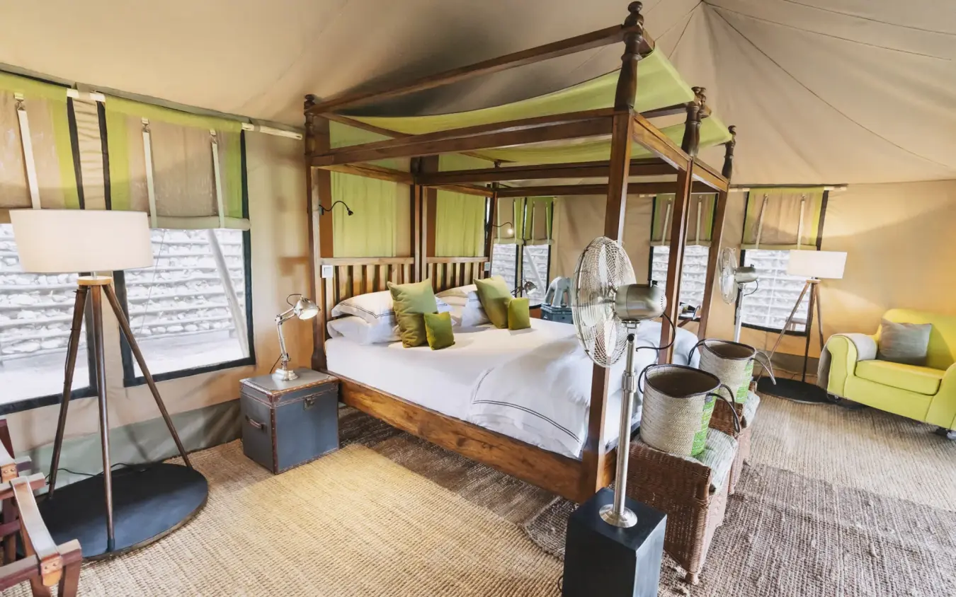 Spacious safari tent bedroom with four-poster bed and green accents, Little Chem Chem, Lake Manyara, Tanzania