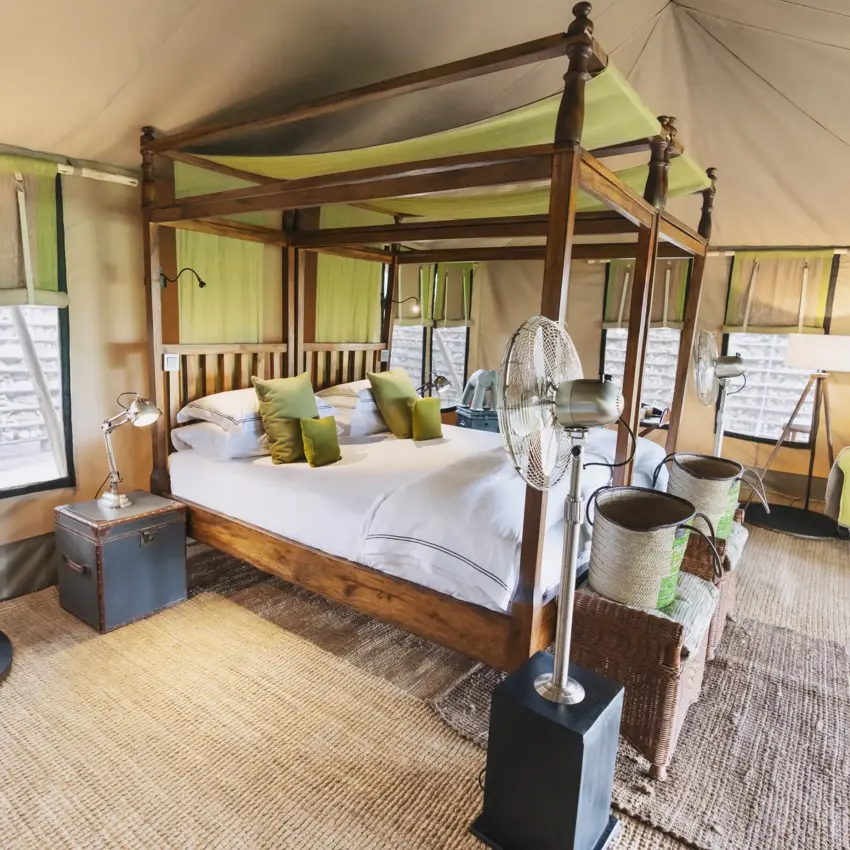 Spacious safari tent bedroom with four-poster bed and green accents, Little Chem Chem, Lake Manyara, Tanzania