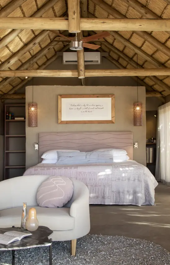 Luxury bedroom suite with exposed wooden beams and ceiling fan, Little Kulala, Sossusvlei, Namibia