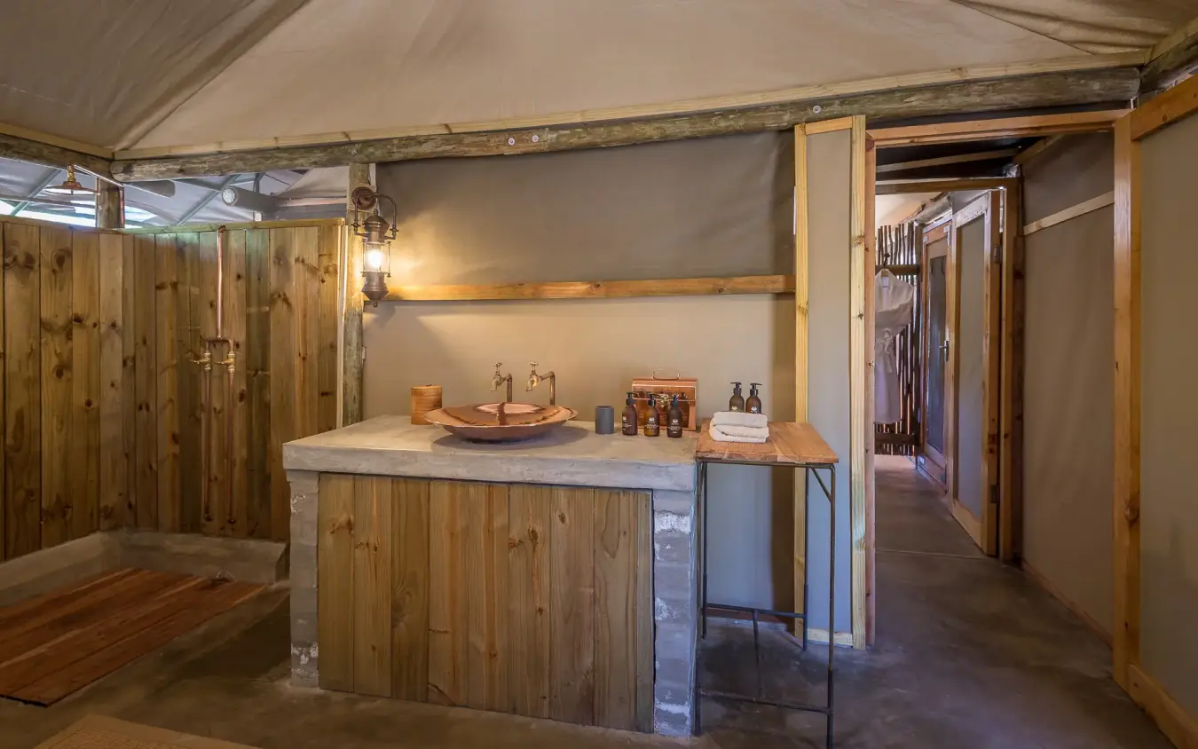 Luxury safari lodge bathroom with wooden finishes and stone countertop, Little Makalolo, Hwange National Park, Zimbabwe