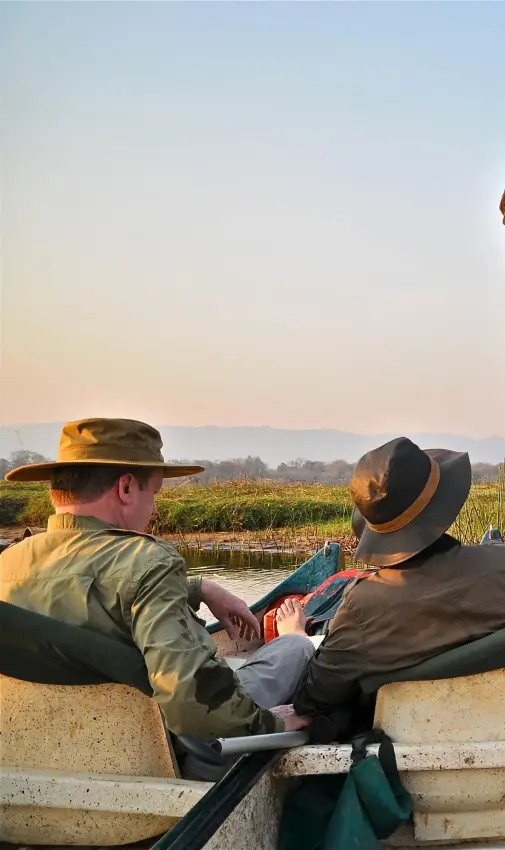 Guests in boat observing elephant bathing in water, Little Vundu, Mana Pools, Zimbabwe