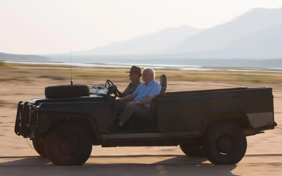 Guests in open safari vehicle on expansive plains landscape, Little Vundu, Mana Pools, Zimbabwe