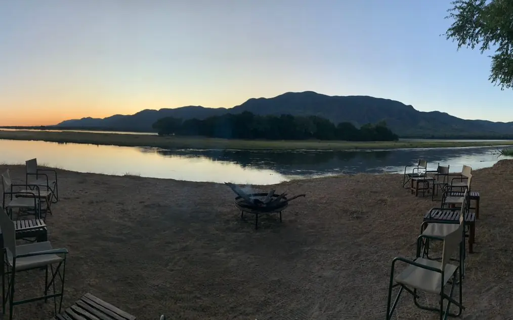 Riverside seating area at sunset with mountain backdrop, Little Vundu, Mana Pools, Zimbabwe