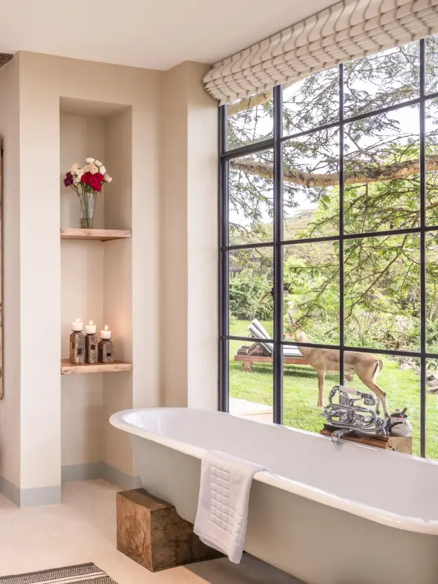Luxury bathroom with freestanding tub and countryside views through large windows, Loldia House, Rift Valley Lakes, Kenya