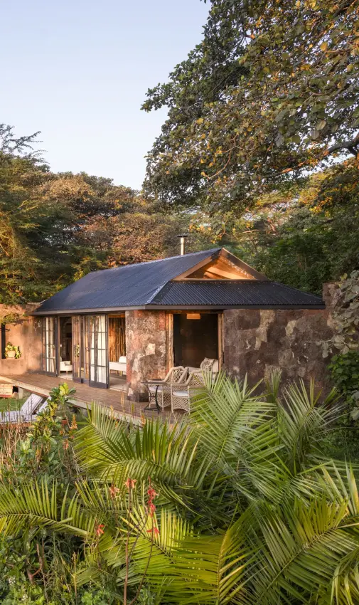 Luxury lodge nestled among trees with manicured tropical gardens at dusk, Loldia House, Rift Valley Lakes, Kenya