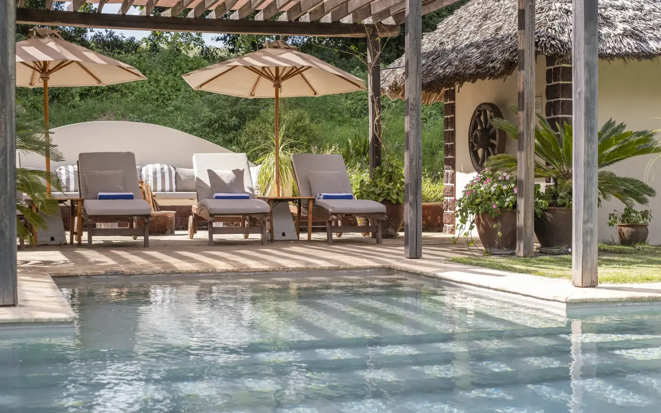 Luxury pool with loungers under pergola and thatched-roof buildings, Loldia House, Rift Valley Lakes, Kenya