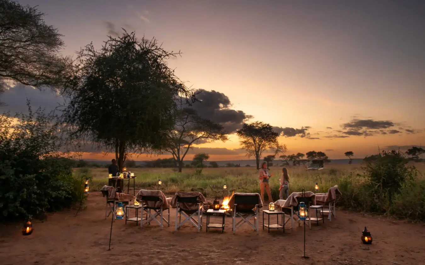 Safari camp dining setup at sunset with acacia trees, Lolkisale Camp, Tarangire National Park, Tanzania