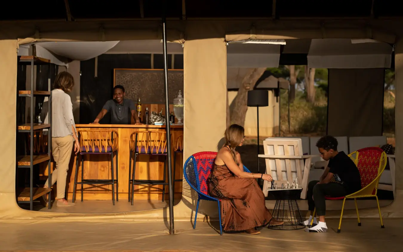 Open-air lounge with guests relaxing in evening light, Lolkisale Camp, Tarangire National Park, Tanzania