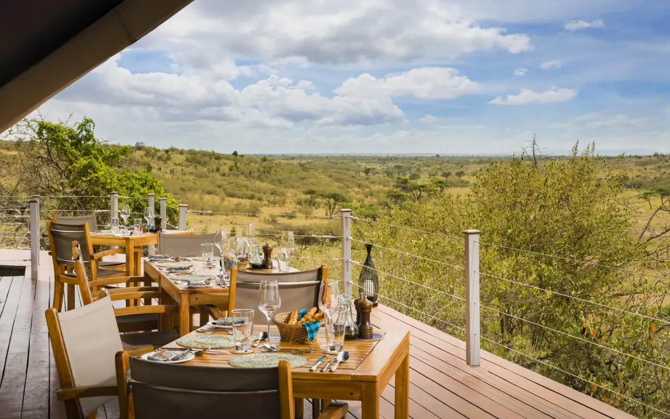 Dining deck overlooking savanna landscape with wildlife habitat, Mahali Mzuri, Maasai Mara, Kenya