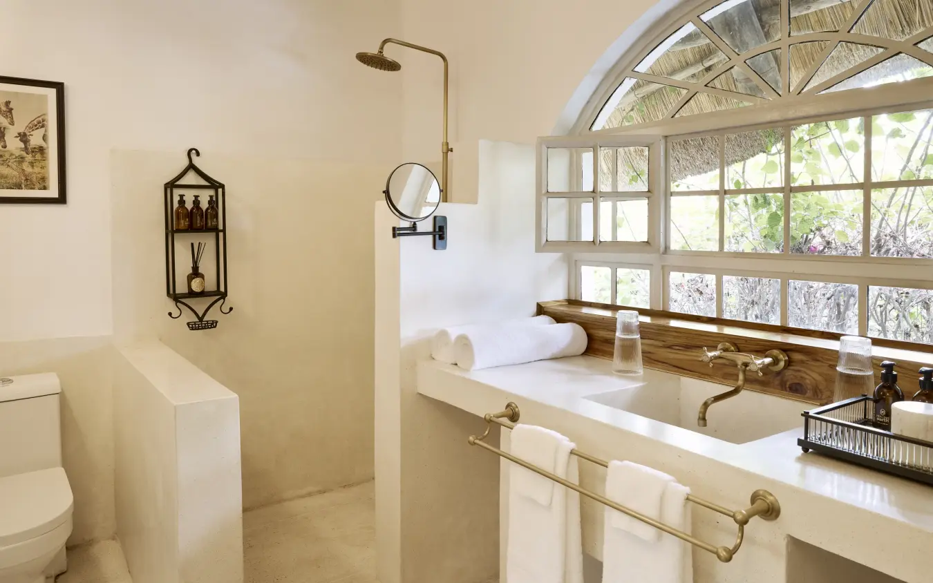 Luxury bathroom with soaking tub and expansive arched windows overlooking bush vegetation, Mama Simba, Arusha, Tanzania