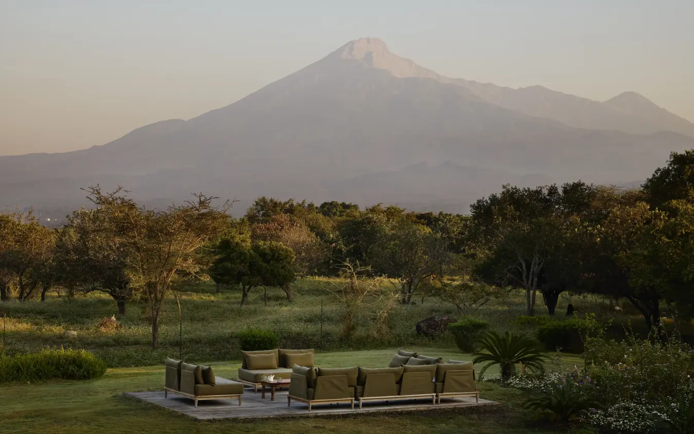 Outdoor lounge seating overlooking volcanic mountain and savanna woodland, Mama Simba, Arusha, Tanzania