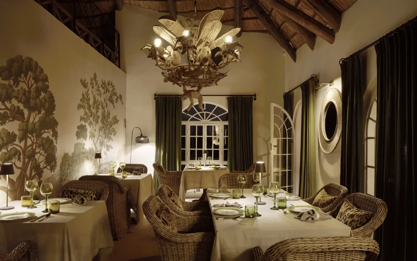 Fine dining room with thatched ceiling and wicker chairs at night, Mama Simba, Arusha, Tanzania