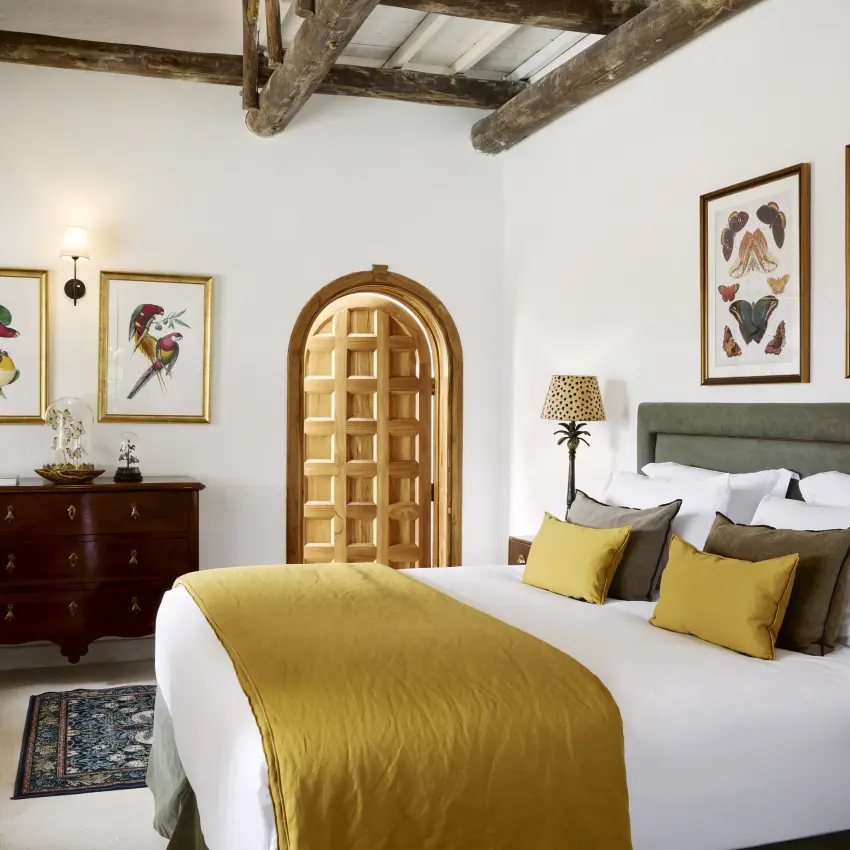 Bedroom interior with exposed beams, arched doorway and butterfly artwork, Mama Simba, Arusha, Tanzania