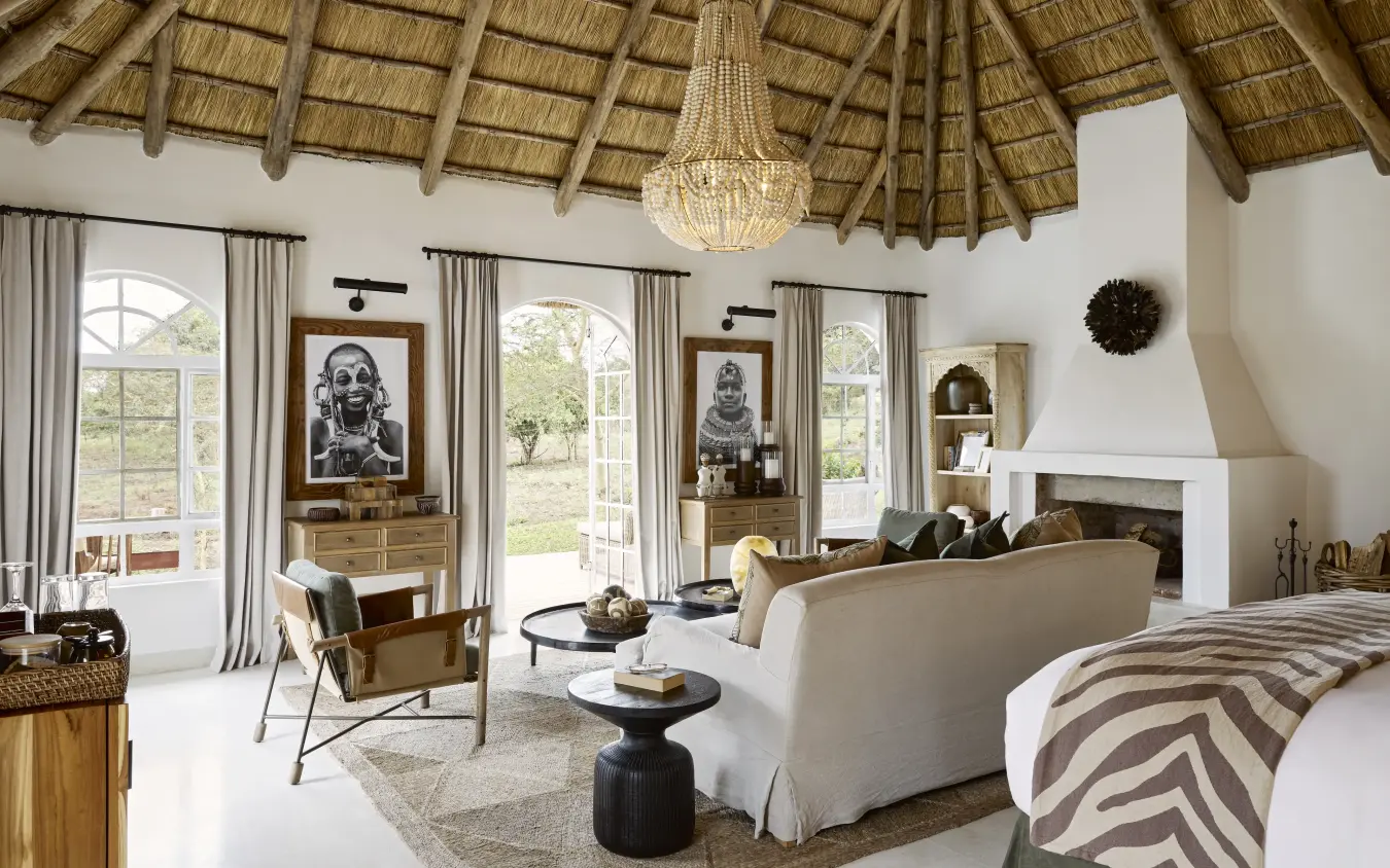 Luxury bedroom suite with thatched ceiling and fireplace overlooking gardens, Mama Simba, Arusha, Tanzania