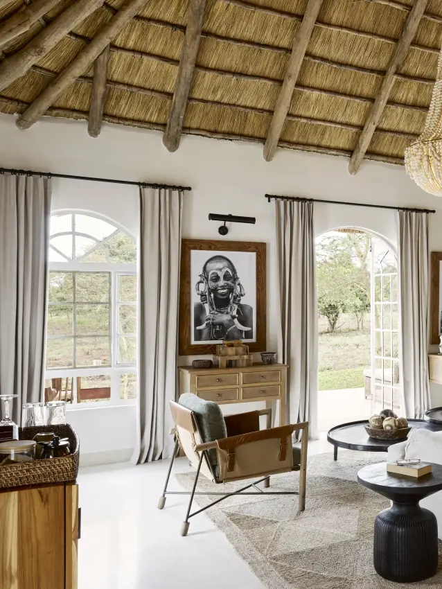 Luxury bedroom suite with thatched ceiling and fireplace overlooking gardens, Mama Simba, Arusha, Tanzania