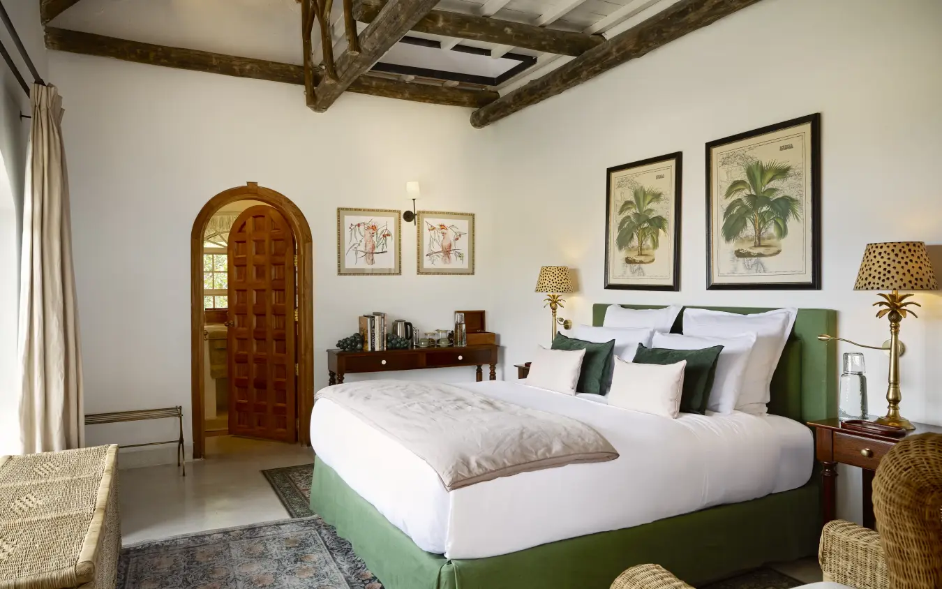 Luxury bedroom with green upholstered bed and exposed wooden beams, Mama Simba, Arusha, Tanzania