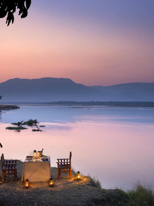 Riverside dinner setup at dusk with distant mountains, Zambezi Expeditions, Mana Pools, Zimbabwe