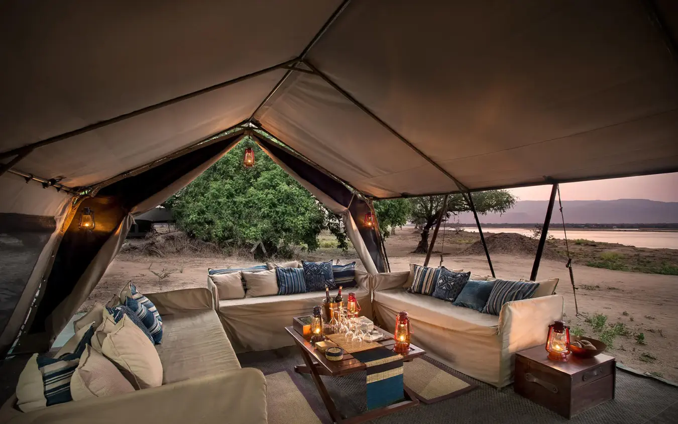 Luxury tent lounge with seating overlooking river at dusk, Zambezi Expeditions, Mana Pools, Zimbabwe