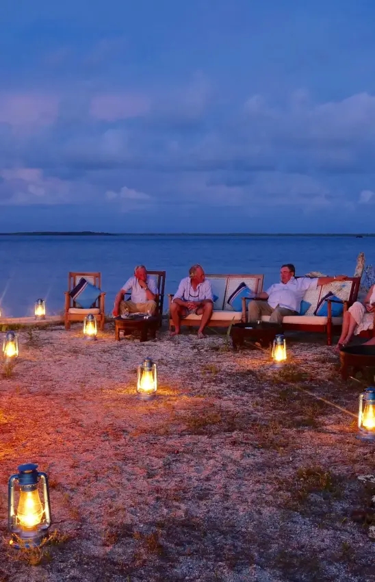 Beach bonfire gathering at dusk with ocean horizon, Manda Bay, Lamu Archipelago, Kenya