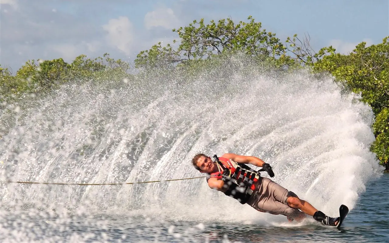 Man wakeboarding behind boat in tropical waters, Manda Bay, Lamu Archipelago, Kenya