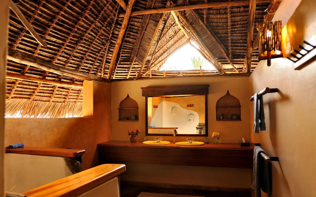 Bathroom with double vanity, thatched roof, warm lighting, Manda Bay, Lamu Archipelago, Kenya